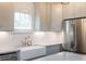 Stainless steel refrigerator and white farmhouse sink in kitchen at 59 Ashe St, Charleston, SC 29403