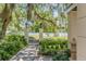 Landscaped garden with a gate, stone path, and oak trees at 106 W Shipyard Rd, Mount Pleasant, SC 29464
