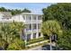 Two-story white house with a balcony, lush landscaping, and a black fence at 106 W Shipyard Rd, Mount Pleasant, SC 29464