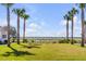 Expansive grassy lawn with white adirondack chairs overlooking the water at 9844 Haven Loop, Johns Island, SC 29455
