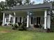 White cottage with a black metal roof, porch, and American and state flags at 106 Church St, Reevesville, SC 29471