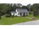 Charming white cottage with a metal roof, porch, and well-manicured lawn at 106 Church St, Reevesville, SC 29471