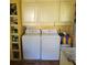 Functional laundry room with washer, dryer, and upper cabinets at 106 Church St, Reevesville, SC 29471