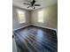 Bright bedroom with two windows, ceiling fan, and wood-look flooring at 7629 Pinehurst St, North Charleston, SC 29420
