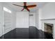 Bedroom with dark hardwood floors, ceiling fan, built-in cabinets, and fireplace at 106 Church St # D, Charleston, SC 29401