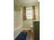 Clean bathroom with tub shower, window, and wood-look floors at 309 Wintergreen Rd, Walterboro, SC 29488