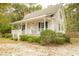 White cottage with a wraparound porch and lush landscaping at 309 Wintergreen Rd, Walterboro, SC 29488
