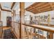 Elegant upper hallway with wood flooring, exposed beams, and a grand staircase at 1408 Palmetto Blvd, Edisto Island, SC 29438