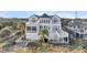 Aerial view of a beach house with large deck, stairs, and surrounding landscape at 1408 Palmetto Blvd, Edisto Island, SC 29438