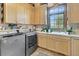Bright laundry room with washer, dryer, and ample cabinet space at 1408 Palmetto Blvd, Edisto Island, SC 29438