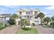 Three-story beach home with a brick driveway and lush landscaping at 1408 Palmetto Blvd, Edisto Island, SC 29438