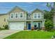 Two-story house with gray siding, blue door, and landscaped lawn at 297 Oglethorpe Cir, Moncks Corner, SC 29461