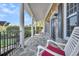 Inviting front porch with stone flooring, white columns, and rocking chairs at 1000 Rivershore Rd, Charleston, SC 29492