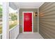 Inviting front porch with a red door and white railings at 2679 Oregon Ave, North Charleston, SC 29405