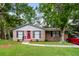 Brick ranch home with red door and landscaped yard at 708 Beech Hill Rd, Summerville, SC 29485