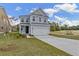 Two-story Craftsman home with gray siding, white trim, and a two-car garage at 424 Grove End Rd, Moncks Corner, SC 29461