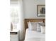 Bright bedroom with a rattan bed frame, neutral bedding, and a window with sheer curtains at 424 Grove End Rd, Moncks Corner, SC 29461