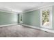Spacious bedroom with carpet flooring, soft green walls, and multiple windows at 7848 Pelican Bay Dr, Awendaw, SC 29429