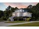Two-story home with large deck, driveway, and landscaping at 7848 Pelican Bay Dr, Awendaw, SC 29429