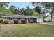 Brick ranch home with black shutters, a white garage, and well-manicured lawn at 205 Whitesville Rd, Moncks Corner, SC 29461