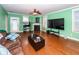 Bright living room with hardwood floors, fireplace, and large TV at 208 Sweetspire Ln, Summerville, SC 29483
