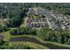 Aerial view of a neighborhood surrounded by mature trees and two large ponds at 208 Sweetspire Ln, Summerville, SC 29483