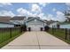 Two-car garage with a concrete driveway and a manicured lawn, fenced with black aluminum at 208 Sweetspire Ln, Summerville, SC 29483