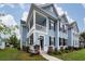 Charming two-story home with a covered porch and balcony, complemented by lush landscaping at 208 Sweetspire Ln, Summerville, SC 29483