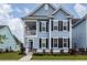Two-story light blue house with dark shutters and a porch at 208 Sweetspire Ln, Summerville, SC 29483