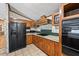 Kitchen with wood cabinets, black appliances, and a green tile backsplash at 170 Renau Blvd, Summerville, SC 29483