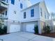 Two-car garage with white doors and landscaping at 1449 Jeremy Cay Ct, Awendaw, SC 29429