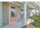Inviting front porch with coral door and brick facade at 620 Chigwell Springs Ln, Summerville, SC 29486