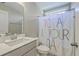 Charming bathroom with white vanity, colorful shower curtain, and bright window at 620 Chigwell Springs Ln, Summerville, SC 29486