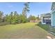 Spacious backyard with grassy lawn, wooden fence, and screened porch at 620 Chigwell Springs Ln, Summerville, SC 29486