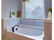 Relaxing bathroom with an oval bathtub and window with mini blinds at 1746 Pierpont Ave, Charleston, SC 29414
