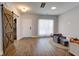 Light-filled entryway with rustic barn door and hardwood floors at 1746 Pierpont Ave, Charleston, SC 29414