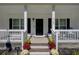 Front porch with rocking chairs, flower pots and black front door at 1746 Pierpont Ave, Charleston, SC 29414