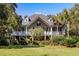 Charming two-story home with a large covered porch, lush landscaping, and beautiful architecture at 3906 Heron Marsh Cir, Johns Island, SC 29455