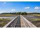 Scenic wooden bridge leading across tranquil marshland at 3906 Heron Marsh Cir, Johns Island, SC 29455