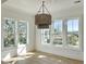 Bright breakfast room features hardwood floors, large windows, and a stunning light fixture at 1467 Jeremy Cay Ct, Awendaw, SC 29429