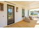 Inviting front porch with wooden flooring, wicker seating, and a dark wooden front door at 1480 Jeremy Cay Ct, Awendaw, SC 29429
