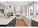 Elegant kitchen with white cabinets, a farmhouse sink, and a large island at 1480 Jeremy Cay Ct, Awendaw, SC 29429