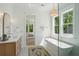 Bright bathroom features a freestanding tub, double vanity, and a view into the bedroom at 1480 Jeremy Cay Ct, Awendaw, SC 29429