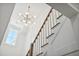 Modern staircase with white railings and a dramatic chandelier at 1480 Jeremy Cay Ct, Awendaw, SC 29429