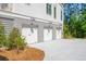 Three-car garage with concrete driveway and exterior lighting at 1480 Jeremy Cay Ct, Awendaw, SC 29429