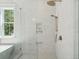Elegant shower with marble tile, rainfall shower head, and built-in shelves at 1480 Jeremy Cay Ct, Awendaw, SC 29429