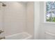 Clean bathroom with white tub and textured tile shower at 1480 Jeremy Cay Ct, Awendaw, SC 29429