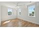 Well-lit bedroom with hardwood floors and multiple windows showcasing a neighborhood view at 1480 Jeremy Cay Ct, Awendaw, SC 29429