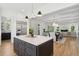 Open kitchen with island, white cabinets, and view into adjacent living space at 1480 Jeremy Cay Ct, Awendaw, SC 29429