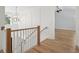 Elegant staircase with wooden railings and light-colored wood floors at 1480 Jeremy Cay Ct, Awendaw, SC 29429